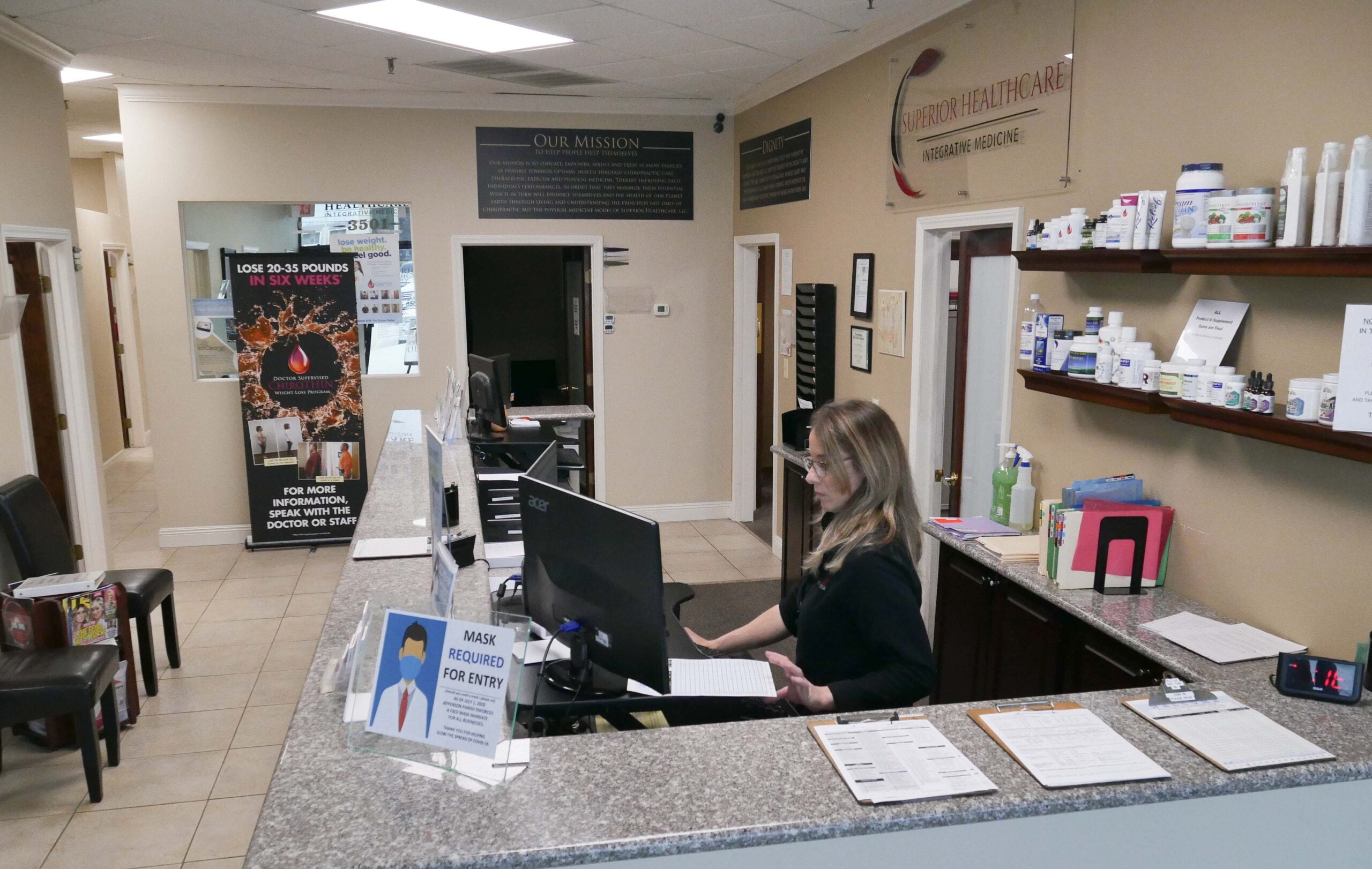 A woman wearing a uniform at the front desk of Superior Healthcare Clinic - Chiropractor Metairie LA A woman wearing a uniform at the front desk of Superior Healthcare Clinic - Chiropractor Metairie LA